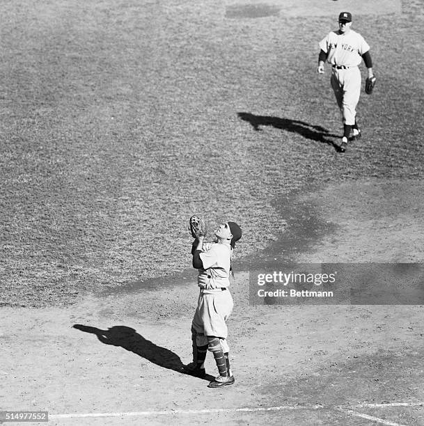 Yankee catcher Yogi Berra seems to be looking to heaven for help, as it waits to receive Ed Stanky's foul pop in the third inning of today's fourth...