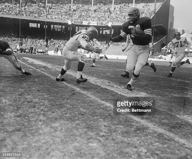 Jim Brown, Cleveland Browns fullback, gets by Redskin Les Watlers after taking a pass from Milt Plum. Brown had his worst day of the season, picking...