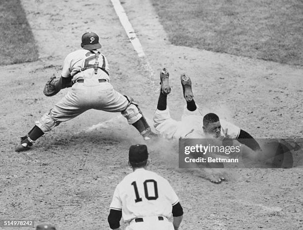 Willie Mays of the New York Giants slides safely into the plate on Wes Westrum's bases-full single in the sixth inning of the game with the...