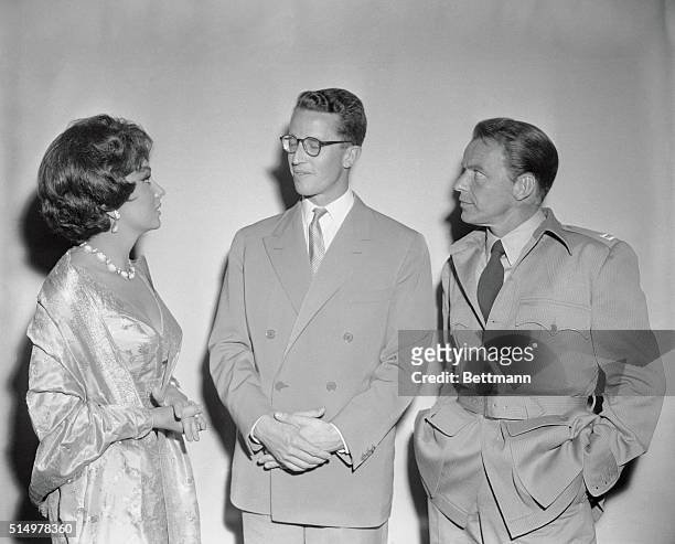 Actress Gina Lollobrigida, in Bulgari jewellery, and actor Frank Sinatra, , chat here with King Baudouin of Belgium during the young Monarch's two...