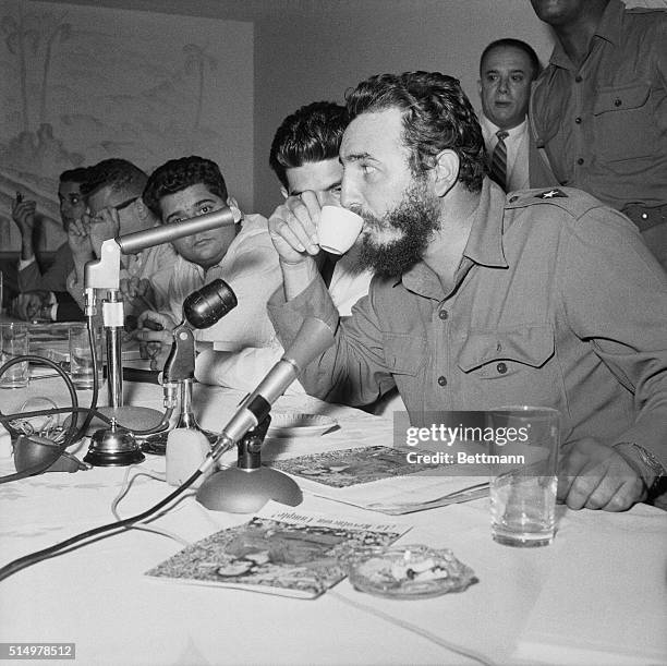 Cuban Premier Fidel Castro takes a coffee break at a press conference here, at which he announced that he would personally attend, "if necessary,"...