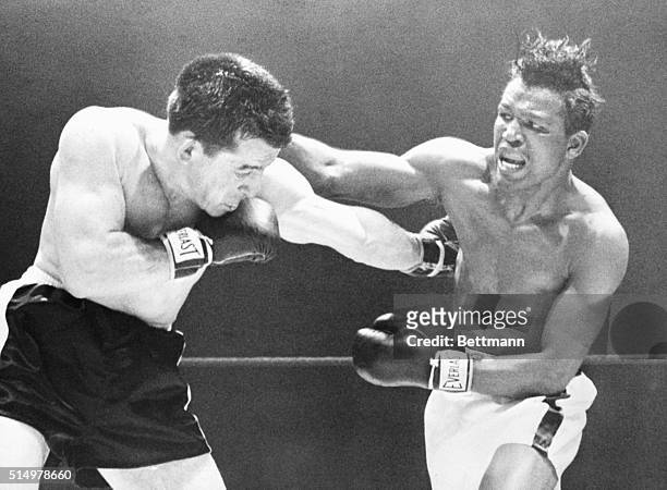Chicago, IL: Middleweight champion Sugar Ray Robinson throws a right over the head of Rocky Graziano , who scores with a hard left to the ribs of...