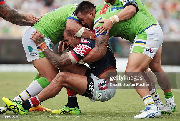 Blake Ferguson of the Roosters is tackled during the round two NRL match between the Canberra Raiders and the Sydney Roosters at GIO Stadium on March...