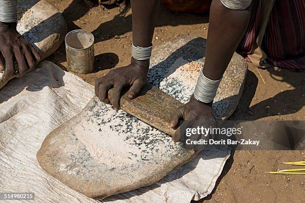 grind seeds to make injera at daasanech village - grinding stock pictures, royalty-free photos & images