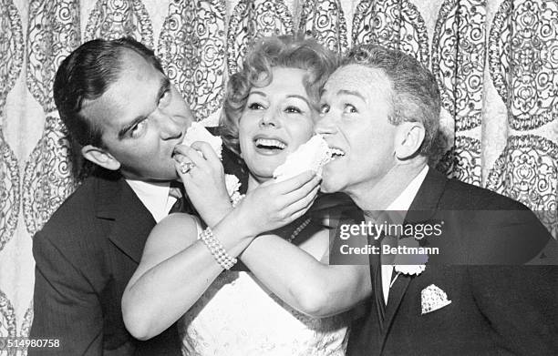 Las Vegas, Nevada: A vivacious Eva Gabor, 33-year-old actress, feeds her wedding cake to her new husband, Richard Brown New York textile executive,...