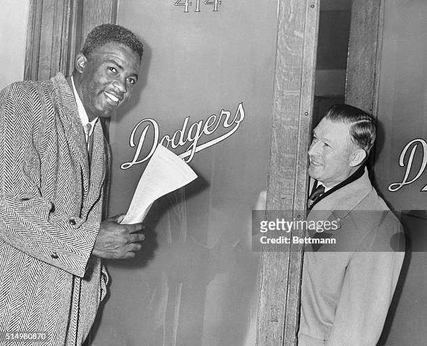 As he left the Dodger office today after signing a 1952 contract for an estimated $40 Jackie Robins on, Brooklyn star second base man waves his new...