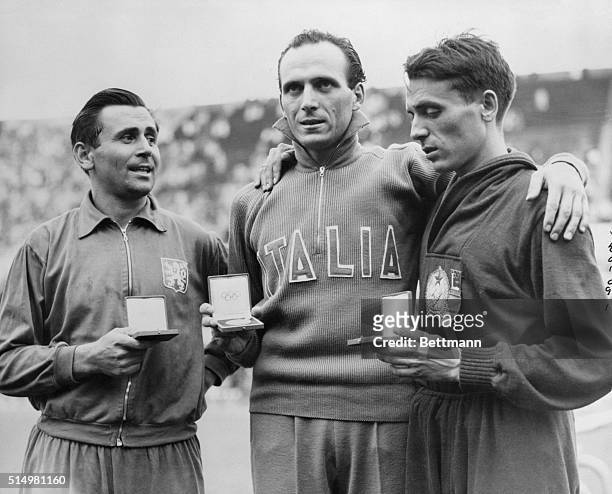 Dordoni of Italy, seen in center with his Gold Medal, after breaking the World Record for the 50 KM Walk- on left is A. Roka, of Hungry, who was 3rd...