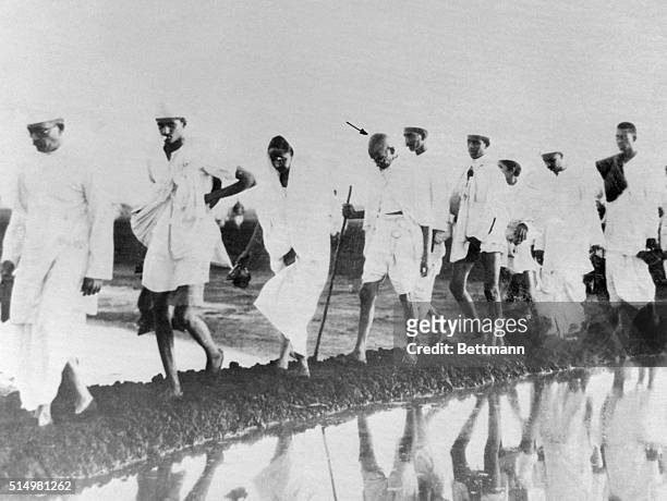 Mahatma Gandhi and some of his followers on their way to the shore at Dandi to break the salt laws by scooping up salt water and evaporating. The...
