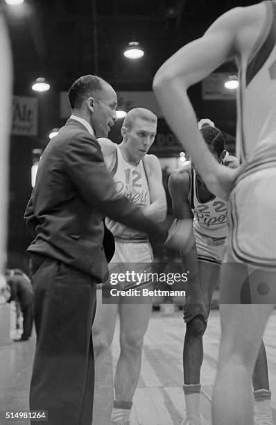 Cleveland, Ohio: John B. McLendon, Cleveland Pipers coach gives some instructions to Roger Taylor, Number 12, during a game at the Cleveland Arena....