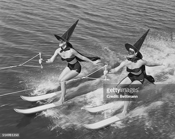 In suitable witches raiment , two sorcerers of Cypress Gardens switch from broomsticks to broomskiis to herald the dawn of Halloween.