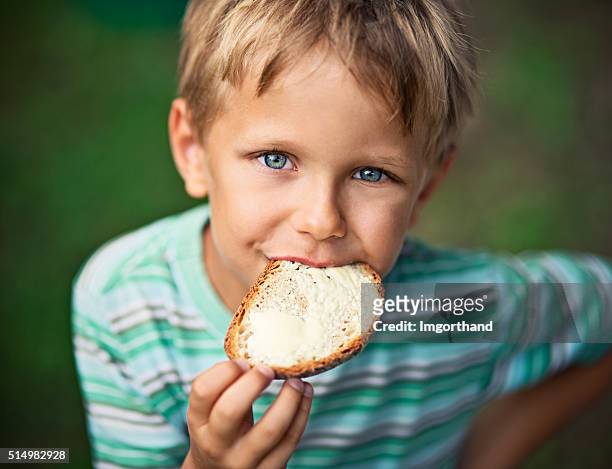little boy eating loaf of bread with butter - bread and butter stock pictures, royalty-free photos & images