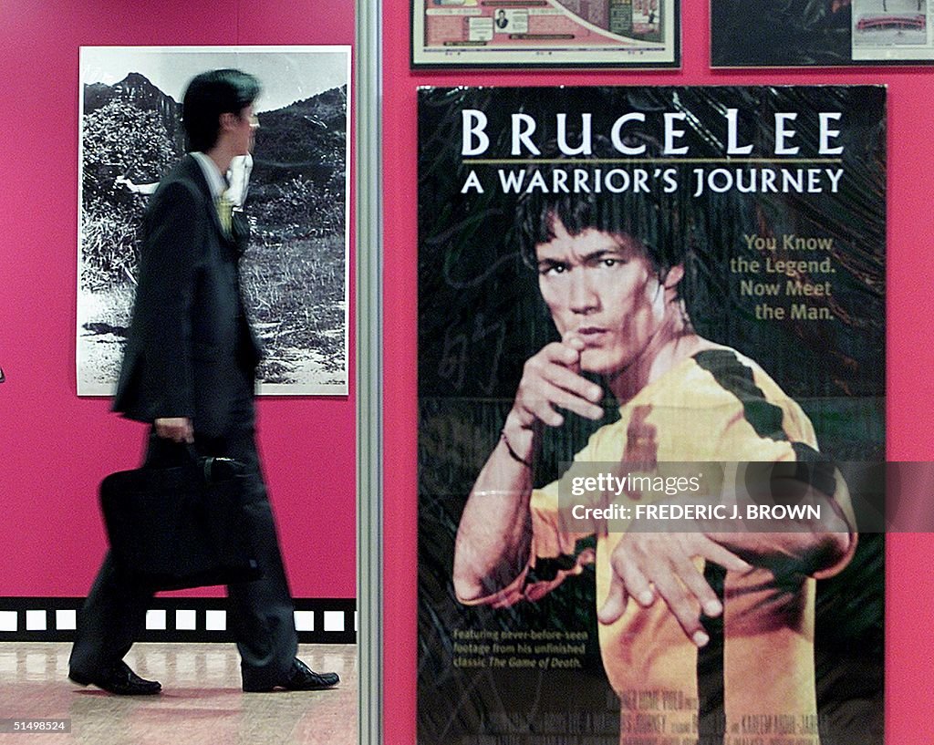 A man walks past artwork of martial arts star Bruc