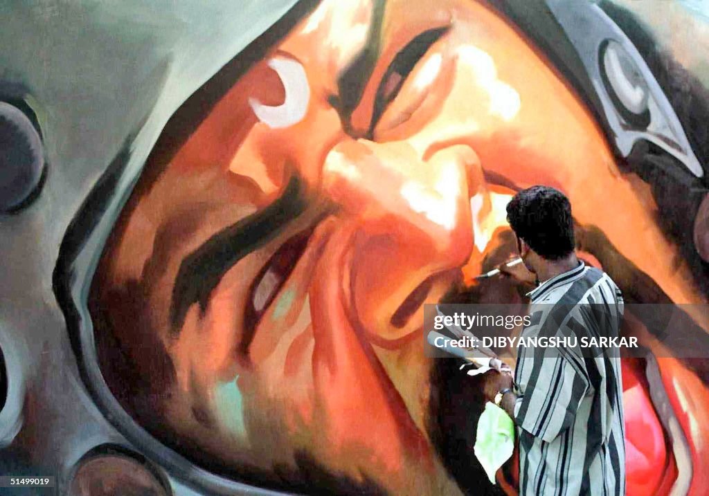 An artist gives the final touch to a billboard pai