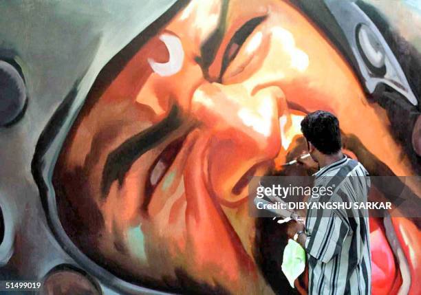 An artist gives the final touch to a billboard painting of Bollywood actor, Pravu Deva at a studio in Madras, 03 July 2001. To promote films in...