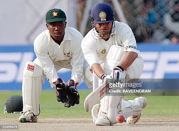 Indian star batsman Sachin Tendulkar sweeps a ball to boundary as Zimbabwe's wicketkeeper Tatenda Taibu looks on during the second day of the second...