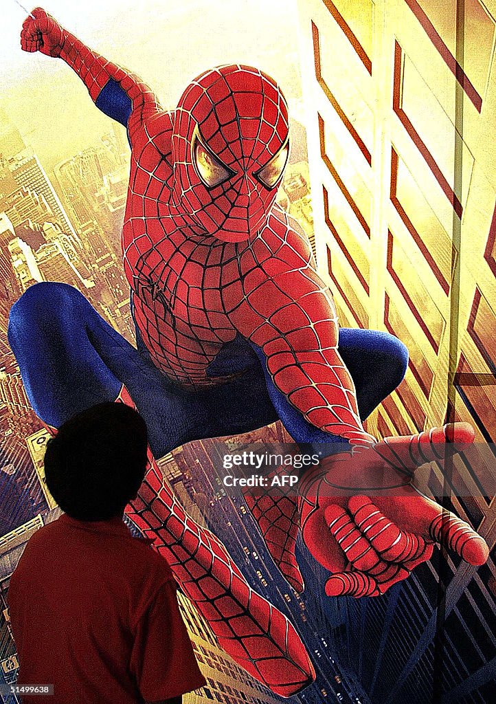 A boy (L bottom) looks at a poster of the movie "S