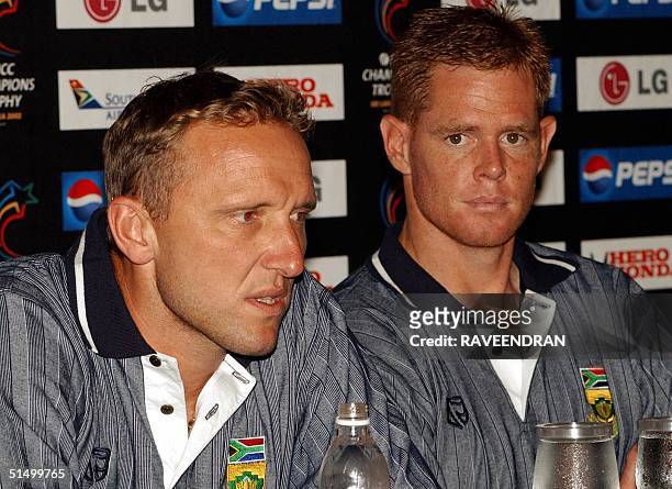 South Africa's star bolwer Allan Donald speak to reporters as captain Shaun Pollock looks on during a press conference in Colombo 24 September 2002....