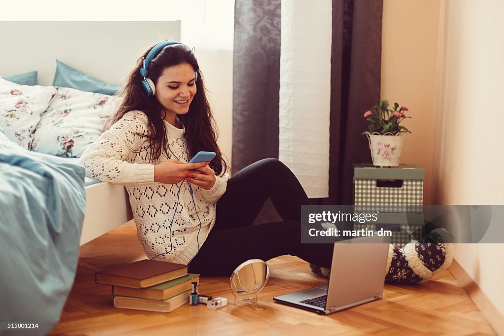 Girl at home text messaging on smartphone
