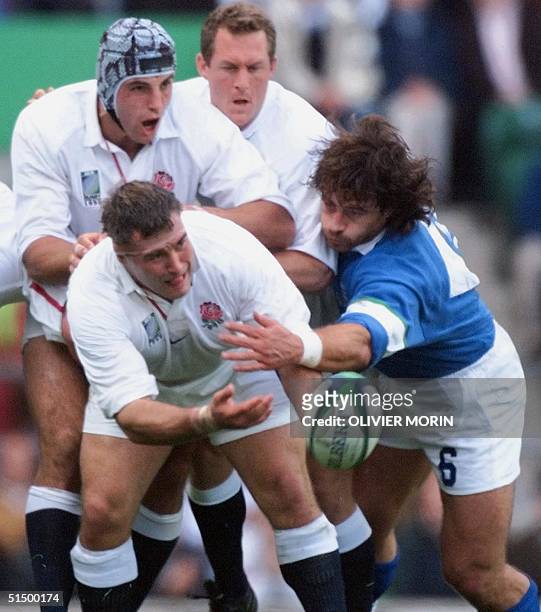 English prop Jason Leonard passes the ball despite pressure from the Italian flanker and captain Massimo Giovanelli during the first-round Rugby...