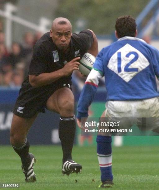 New Zealand winger Jonah Lomu faces Italian centre Sandro Ceppolino as he powers through the opposition during the first-round Rugby World Cup match...