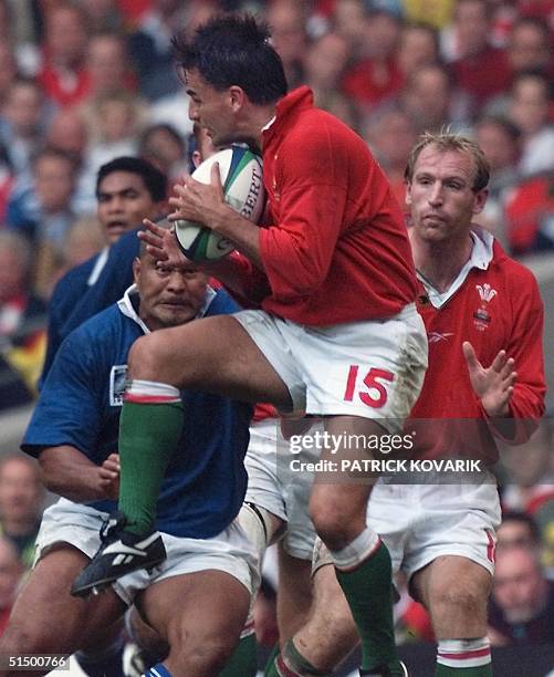 Welsh full-back Shane Howarth catches an aerial ball as Samoan centre Va'aiga Tuigamala arrives to tackle him during the Rugby World Cup first round...