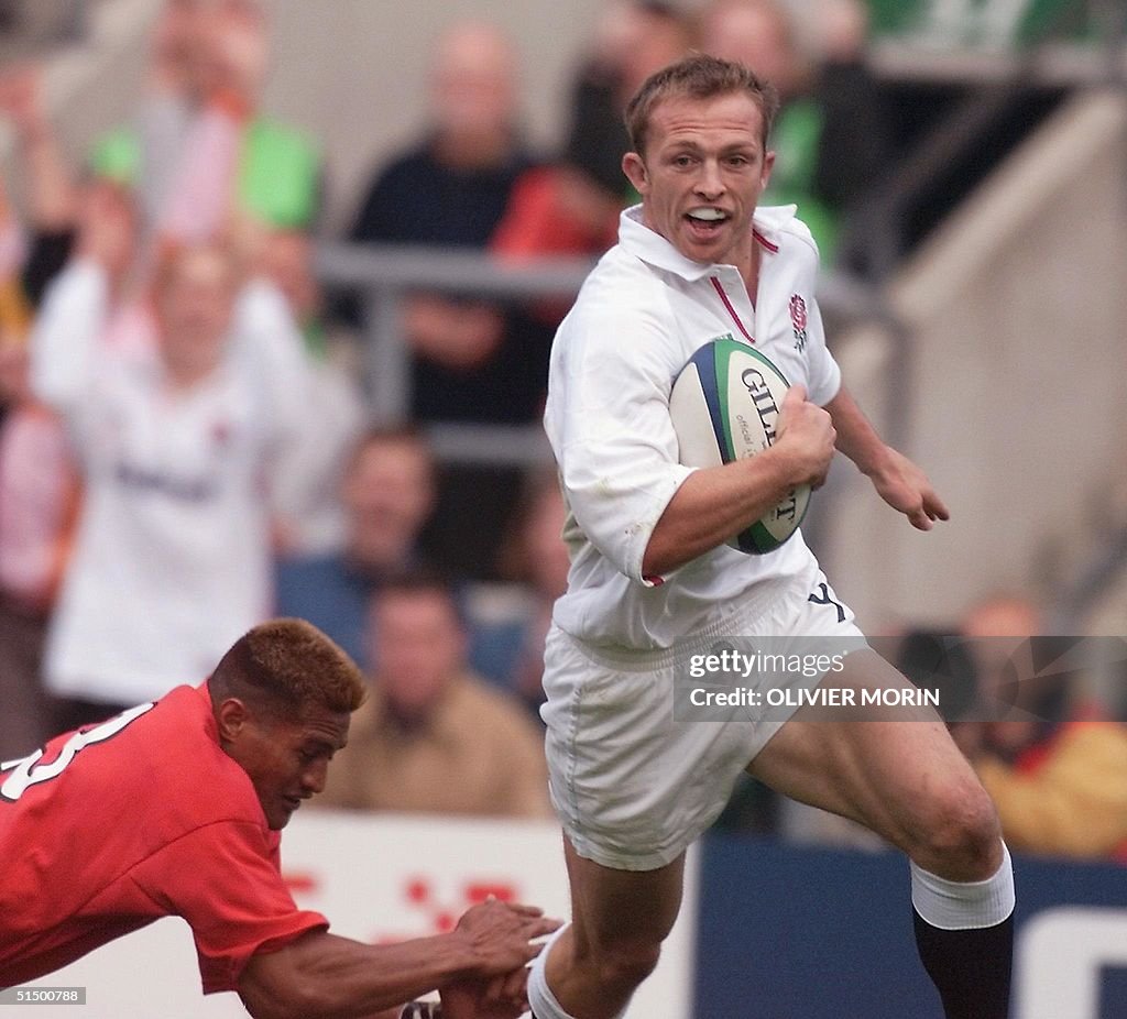 English scrum-half Matt Dawson (R) escapes Tongan