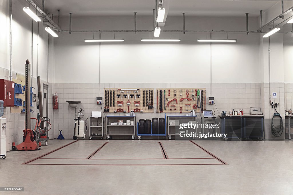 Auto Repair Shop Interior with Mechanic in Background