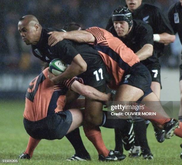 New Zealand winger Jonah Lomu is tackled by Scottish scrum-half and captain Gary Armstrong as New Zealand flanker Josh Kronfeld arrives during the...