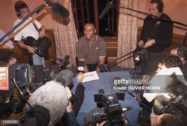 All Black's star winger Jonah Lomu laughs, surrounded by the media, during a press conference 28 October 1999 in Bagshot, southwest of London. New...