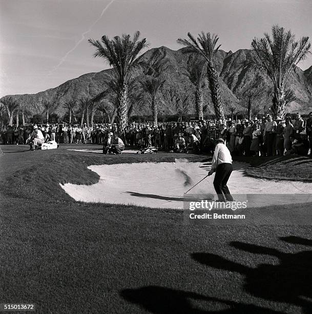 Sammy Snead, captain of the US team, blasts out of a sand trap onto the second green during play in the first round of the British-American Ryder Cup...