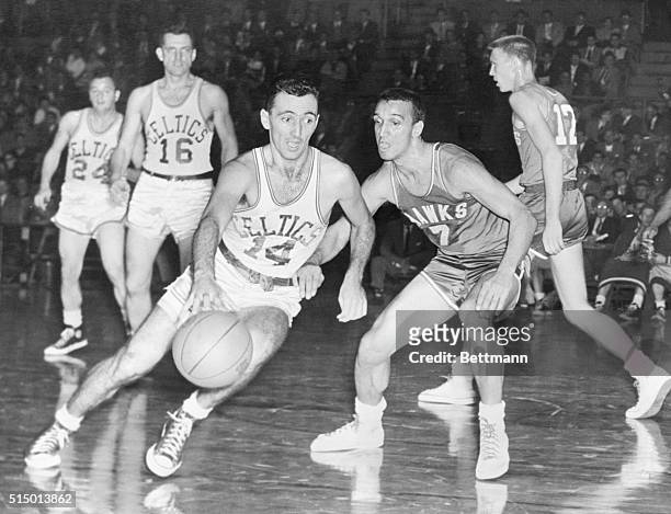 Boston's Bob Cousy tries to dribble past the guard of Milwaukee's Bob Harrison during the third period of their game at the Garden tonight. Boston...