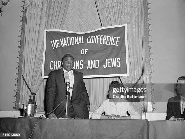 Jackie Robinson of the Brooklyn Dodgers is shown with Mrs. Robinson as he served as moderator at this morning's session of the 29th annual meeting of...
