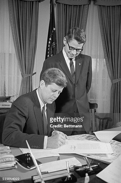 President Kennedy signs the Emergency Feed Grain Bill, giving aid to corn and grain farmers.