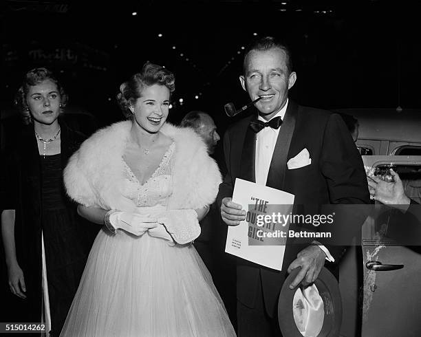 Making one of his rare public appearances outside of business, Bing Crosby is shown with actress Mona Freeman as they attended the gala premiere of...