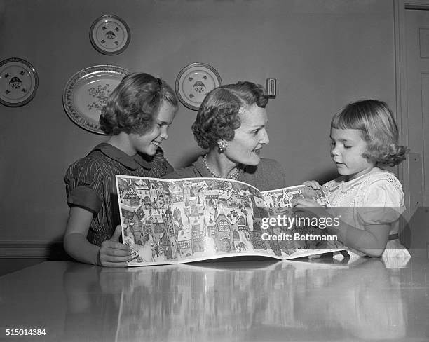 Mrs. Richard Nixon, wife of Vice President Nixon, is shown with their daughters, Julie right, and Patricia center as they look over a "Little...
