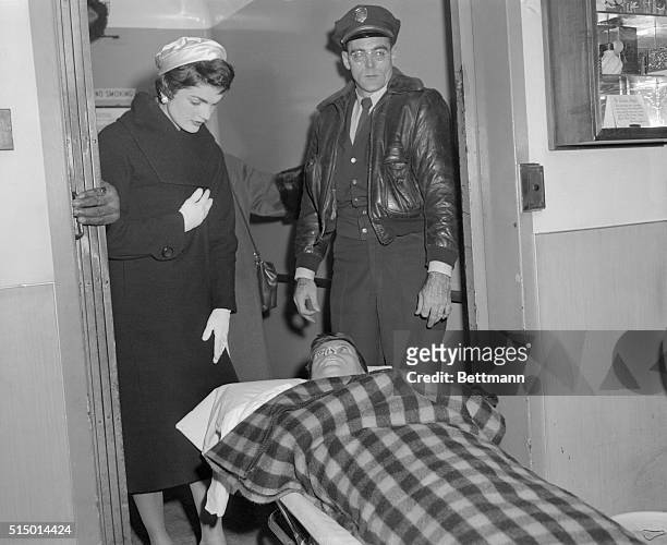 Senator John F. Kennedy, who was operated on for a spinal condition last October 21, is shown being lifted into an ambulance after leaving New York's...