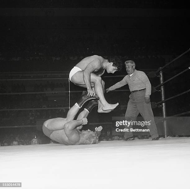 Vittorio Apollo takes a flying leap over the heels of Buddy Rodgers, of Camden, N.J., during their wrestling match at Madison Square Garden, March...