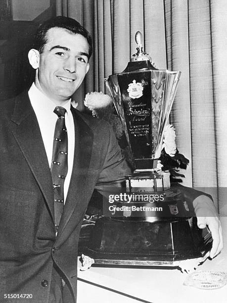 Canada's top gridder. Toronto, Canada: Sam Etcheverry, of the Montreal Alouettes football team, stands proudly beside the Canadian Schenley Trophy...
