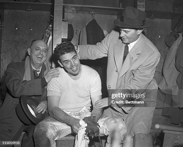 Otto Graham Jr., star of the Cleveland Browns pro football team, is shown with his father, Otto Graham Sr., and coach Paul Brown in the dressing room...