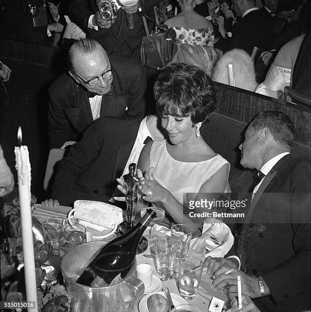 Hollywood, CA- Actress Elizabeth Taylor admires her first "Oscar" at a party following the Academy Award presentation. Miss Taylor won the award as...