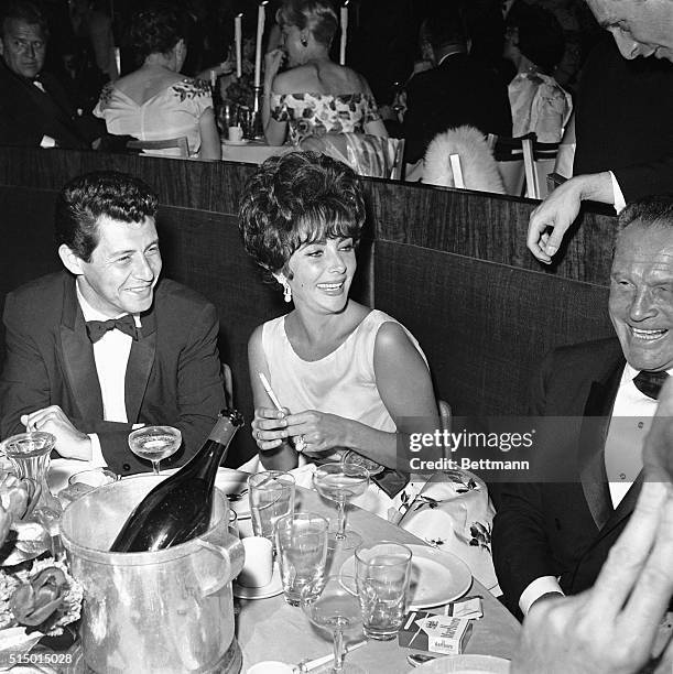Hollywood, CA- Actress Elizabeth Taylor admires her first "Oscar" at a party following the Academy Award presentation. Miss Taylor won the award as...
