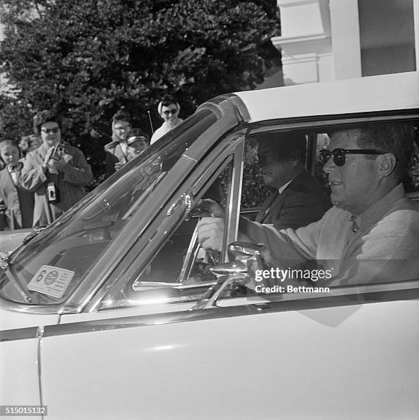 West Palm Beach, Florida: President Kennedy drives his own automobile as he leaves St. Mary's Hospital here 12/30 after a visit with his father. He...