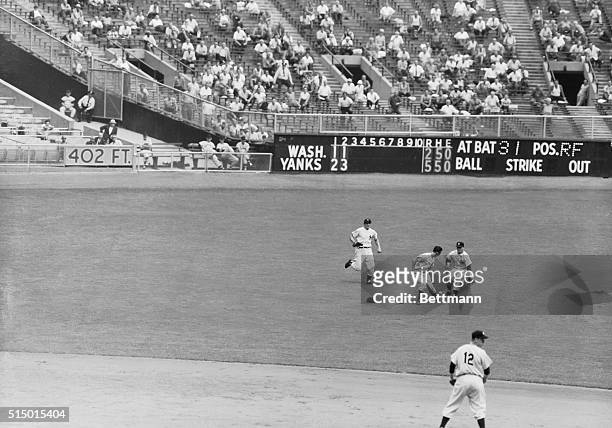 Martin and Mantle of the Yankees arrive too late to catch Sievers' blooper short in the third inning of Today's game with the Washington Senators....