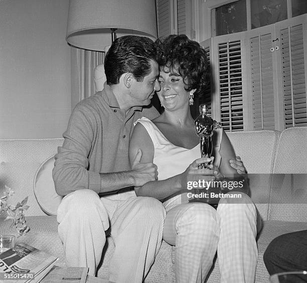 Elizabeth Taylor and her husband Eddie Fisher celebrate her newly won Oscar at a press conference in their suite in the Beverly Hills Hotel. She won...