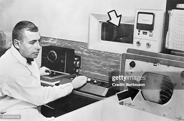 Eugene J. Levine is in the control and viewing room watching the fluroscope , in a television set. He can also view the patient through the window ,...