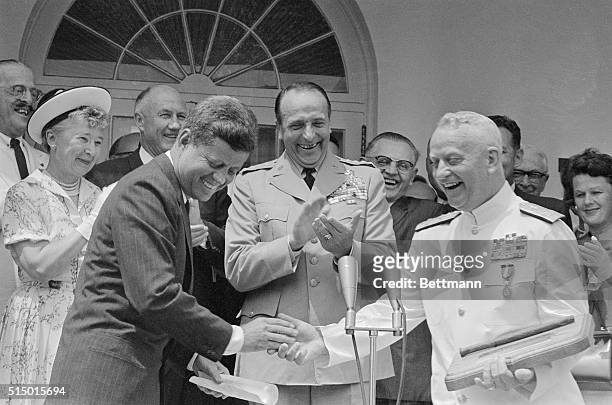 President Kennedy shakes hands with Chief of Naval Operations Arleigh Burke after presenting him with the Distinguished Service Medal at his...