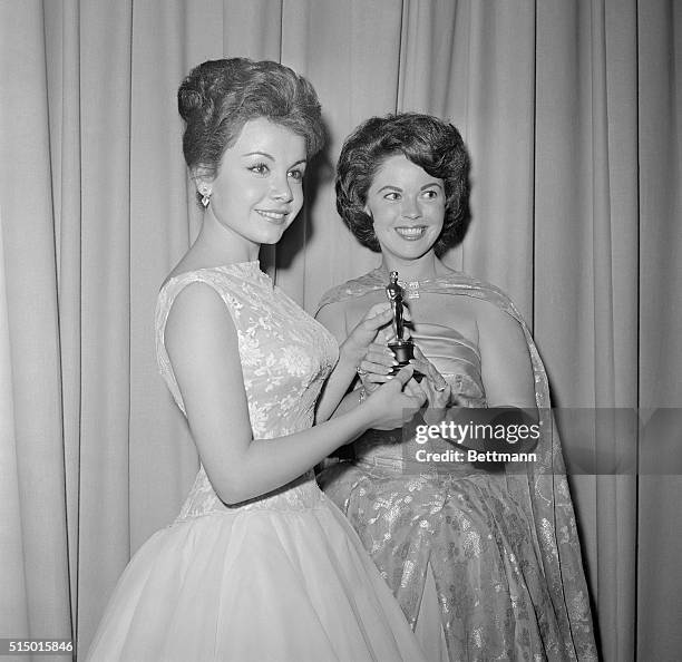 Screen starlet Annette Funicello accepts an Oscar on behalf of Haley Mills, April 17th, from star Shirley Temple. The award was an honorary juvenile...