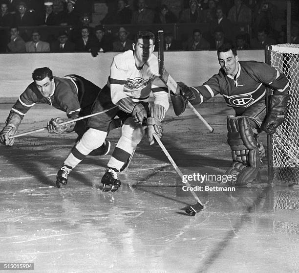 Detroit's Alex Delvecchio has the puck at the end of his stick as he tries to push it past Montreal goalie Jacques Plante during the third period of...