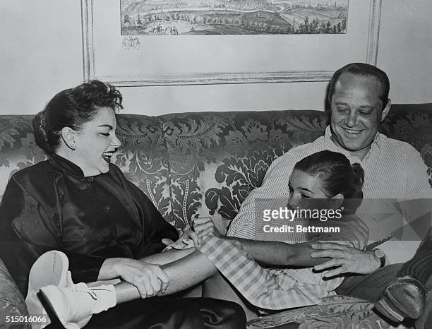 Judy Garland and her manager husband, Sid Luft, are playing with Liza Judy's daughter by her second marriage, in their Plaza Hotel Suite. Judy was...