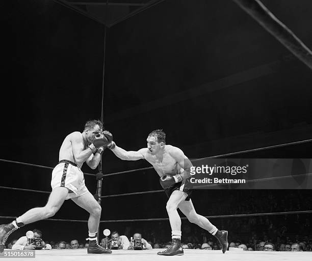 Utah middleweight fighter Gene Fullmer swings a long right and connects with European middleweight champion Charles Humez of France during the fourth...